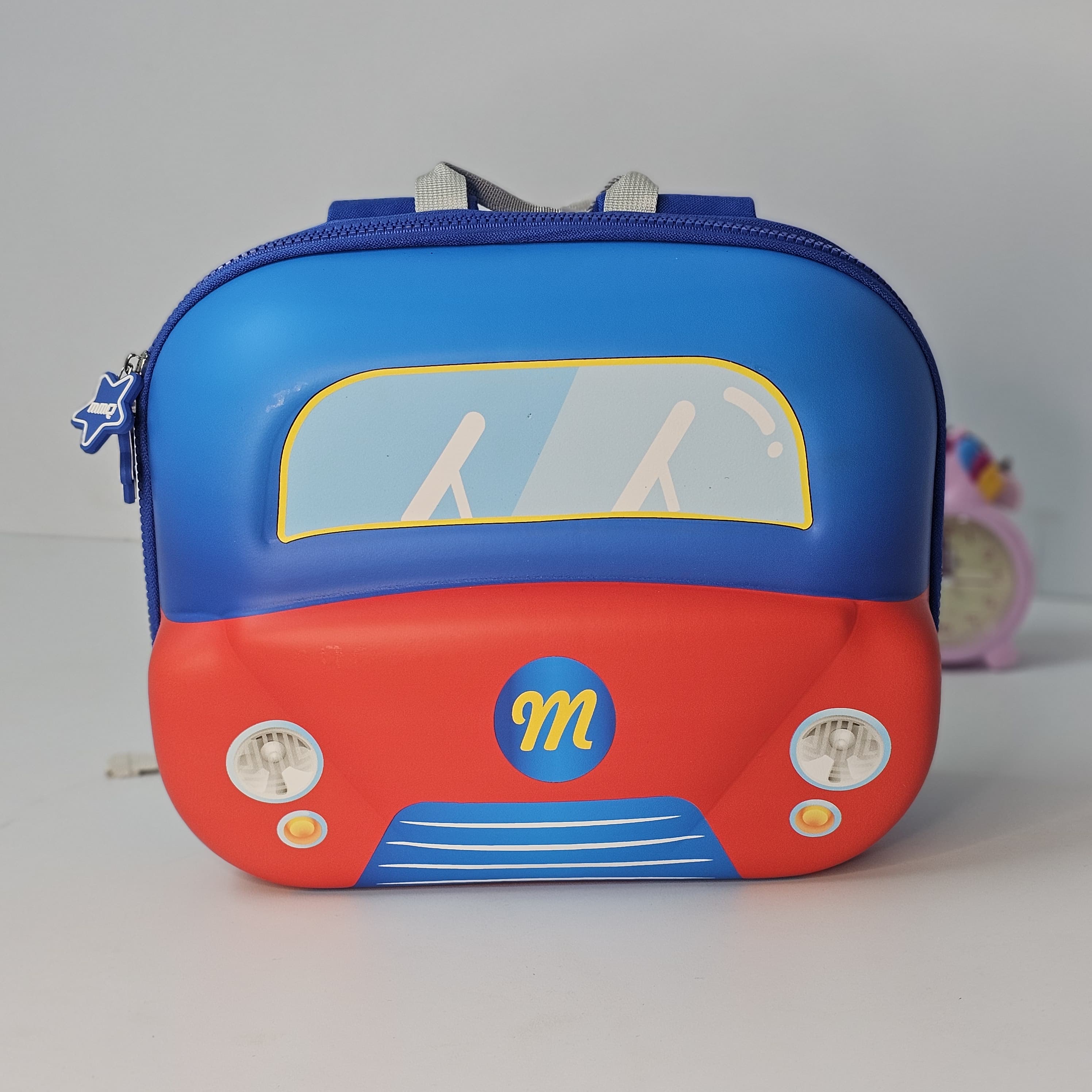 Children's backpack designed like a red car with blue top on a gray background